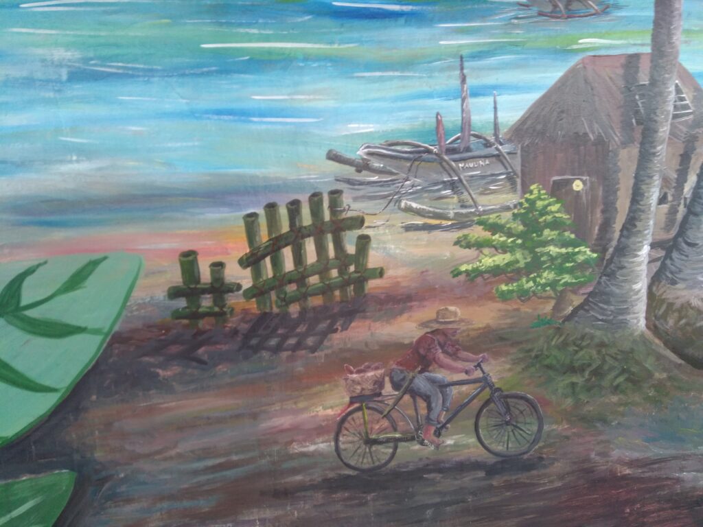 Details from a mural that depict a filipino man cycling in the coastal community Guiuan.